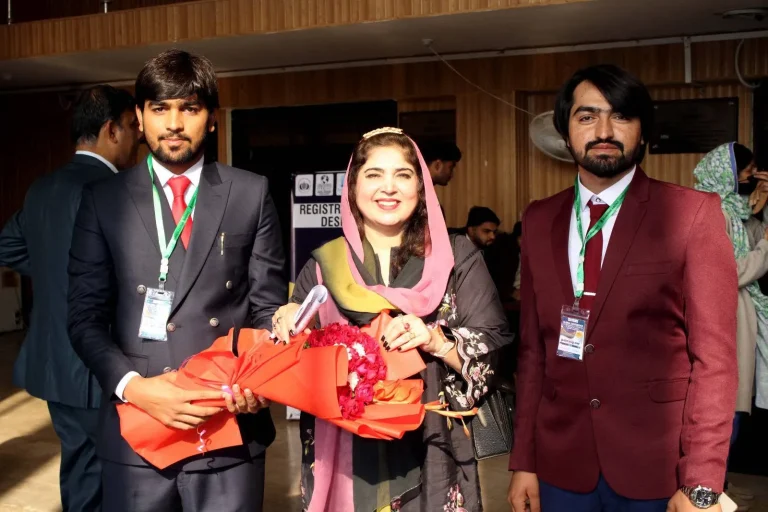 Guest welcomed with a bouquet by student volunteers at the GCHCSS-25 registration area in Multan