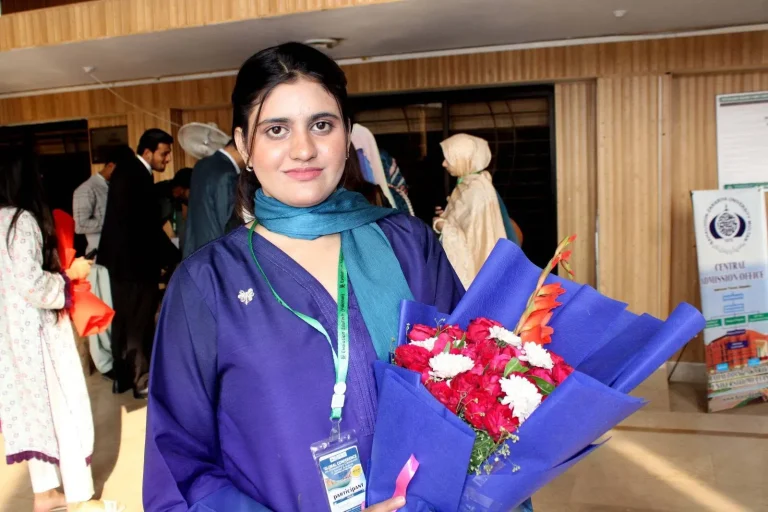 Participant holding her welcome bouquet at GCHCSS-25, Bahauddin Zakariya University, Multan