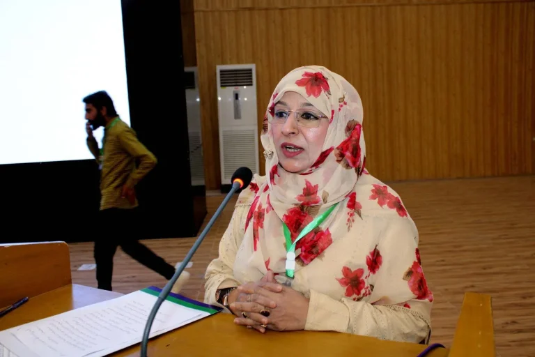 Speaker reading her address at the GCHCSS-25 conference table in Multan