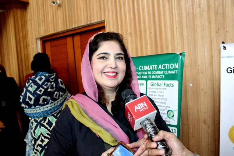 Principal organiser from Bahauddin Zakariya University giving a television interview beside the SDG climate action display at GCHCSS-25