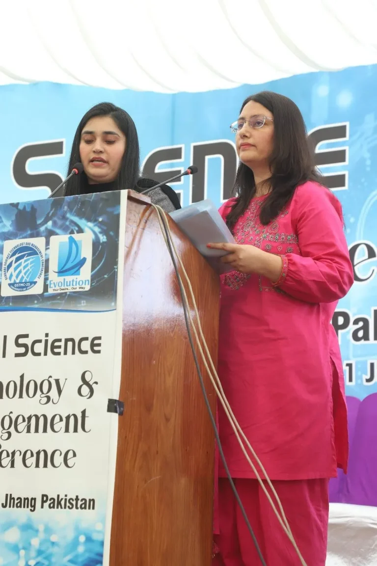 Two presenters reading from the GSTMC-25 rostrum at the University of Jhang