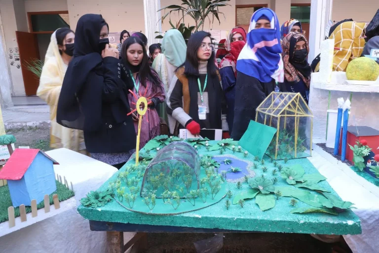 Students looking at green building and environment models at the GSTMC-25 exhibition, University of Jhang