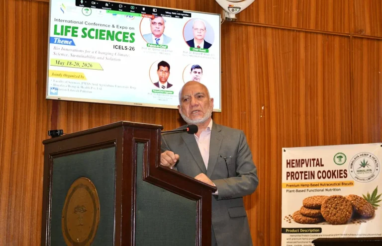 Chief guest speaking at the ICELS-26 rostrum beside the conference theme slide in Rawalpindi