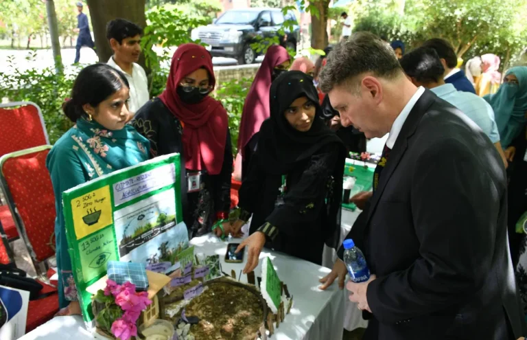 International delegate at a student stall on climate-resilient agriculture, linked to SDG 2 Zero Hunger and SDG 13 Climate Action, at the ICELS-26 expo