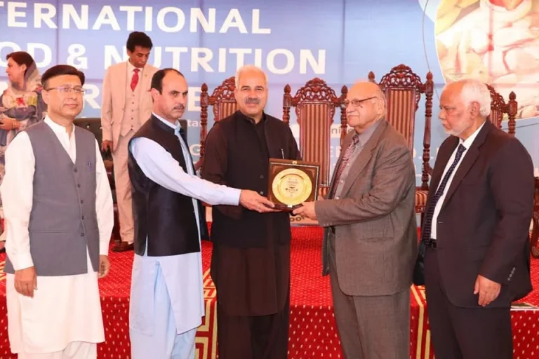 Commemorative shield presented to a guest on stage at the International Food & Nutrition Conference 2022
