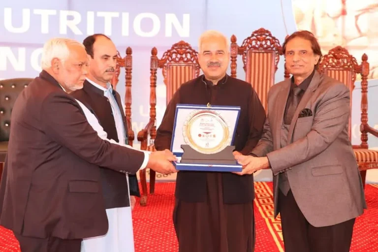 Organisers presenting a shield on stage at the International Food & Nutrition Conference 2022, Swat